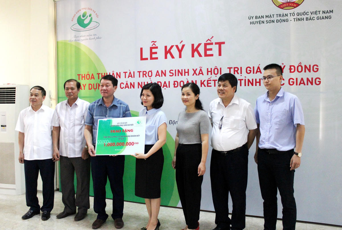 Ảnh: Đại diện lãnh đạo Bệnh viện Phụ sản Hà Nội trao biểu trưng tài trợ 1 tỷ đồng xây dựng nhà Đại đoàn kết.