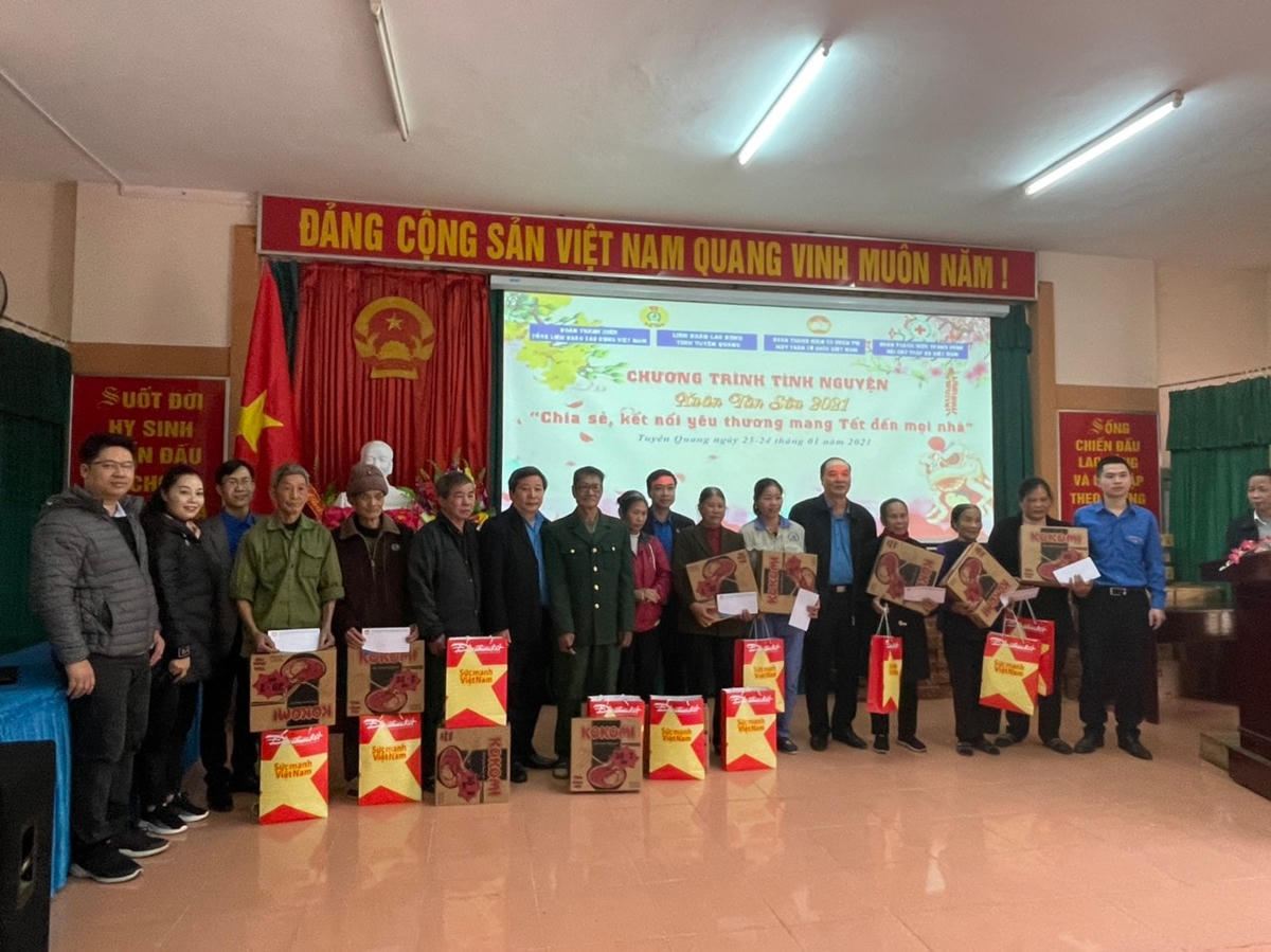 Ông Đào Tiến Mạnh, Bí thư Đoàn thanh niên cơ quan UBTƯ MTTQ Việt Nam (ngoài cùng bên phải) và ông Nguyễn Mạnh Trường Giám đốc Công ty LifeTek (ngoài cùng bên trái) trao quà cho các gia đình chính sách thuộc xã Tứ Quận, huyện Yên Sơn.