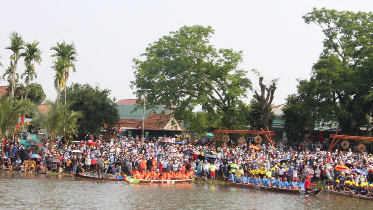 Rất đông người dân đứng dọc bờ sông Tam Kỳ theo dõi đua thuyền.