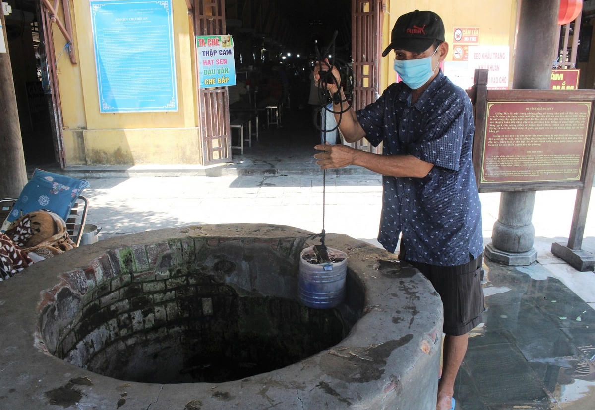 Ông Lê Văn Bê lấy nước từ giếng Máy.  