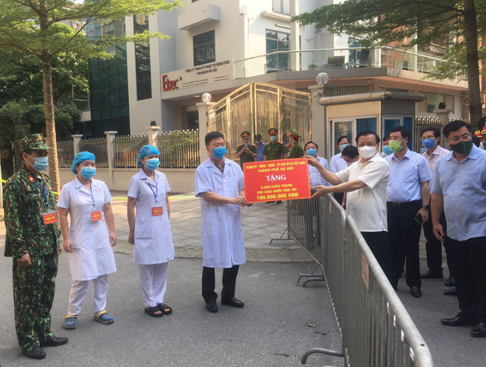Bí thư Thành ủy Hà Nội Đinh Tiến Dũng trao tặng vật dụng phòng chống dịch tại điểm cách ly Pháp Vân - Tứ Hiệp. 