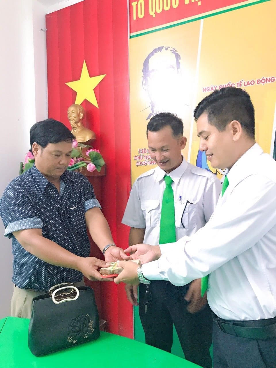 Đại diện taxi Mai Linh Đắk Lắk và tài xế Phạm Văn Sỹ (người ở giữa) trao lại số tài sản bị đánh rơi cho chủ nhân.