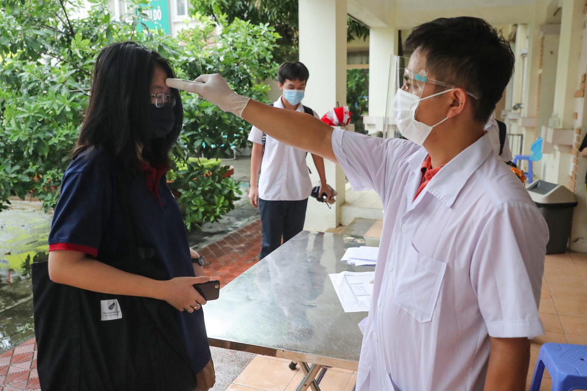 Thí sinh được đo thân nhiệt trước khi làm thủ tục dự thi.