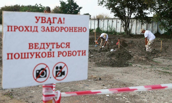 Nhóm khai quật đào bới các hố chôn cất ở thành phố Odessa, Ukraine. Ảnh: AFP.