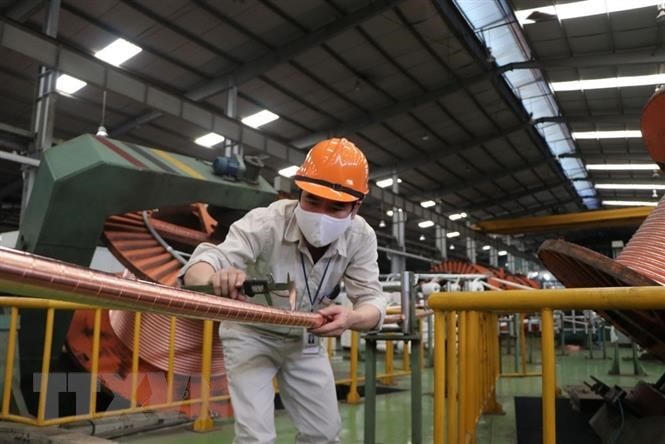 Làm việc trong dịch Covid-19 để thực hiện mục tiêu kép vừa chống dịch vừa phát triển sản xuất. Ảnh: TTXVN.