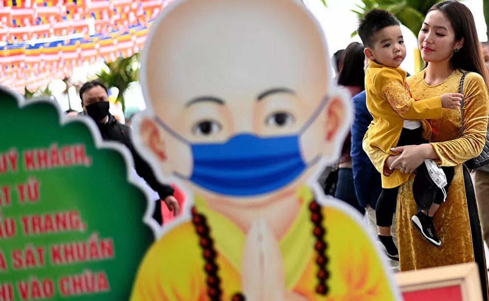 Một phụ nữ Việt Nam bế con đi lễ tại chùa Trấn Quốc, một trong những ngôi chùa cổ nhất ở Hà Nội.