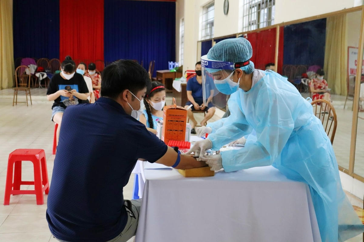 Cán bộ y tế TTYT TP Hạ Long lấy mẫu xét nghiệm nhanh cho người về vùng dịch tại phường Cao Thắng, TP Hạ Long. Ảnh: Báo Quảng Ninh.