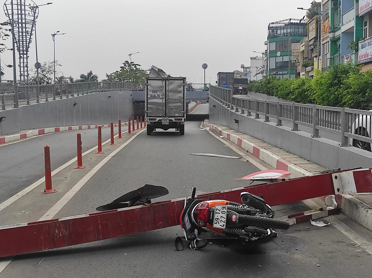 Đôi nam nữ thoát chết trong gang tấc, còn chiếc xe máy bị thanh sắt đè bẹp. Ảnh TL.