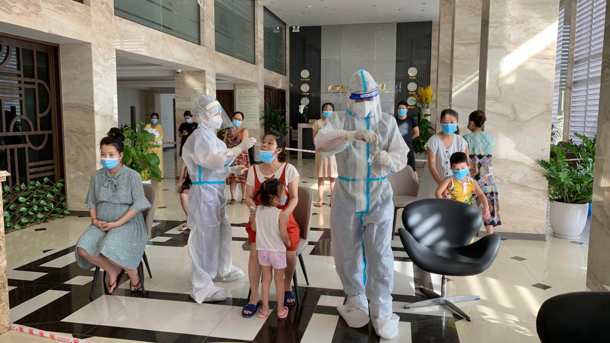 Cán bộ y tế lấy mẫu xét nghiệm sàng lọc các trường hợp mắc Covid-19 đang cách ly tại khách sạn.