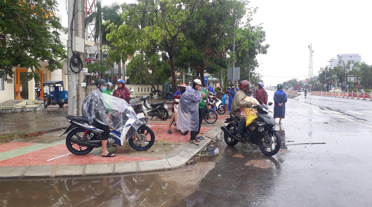 Rất đông người và xe máy đang vật vả chờ đợi có phương tiện trung chuyển để đi.