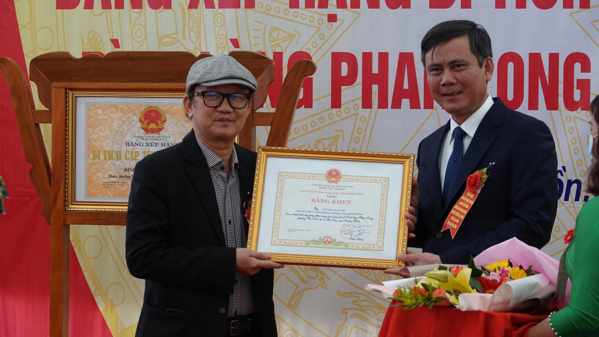 Ông Trần Thắng, Chủ tịch UBND tỉnh Quảng Bình đã trao tặng Bằng khen cho ông Nguyễn Xuân Đức, người có công lớn trong việc xây dựng lại đình làng.