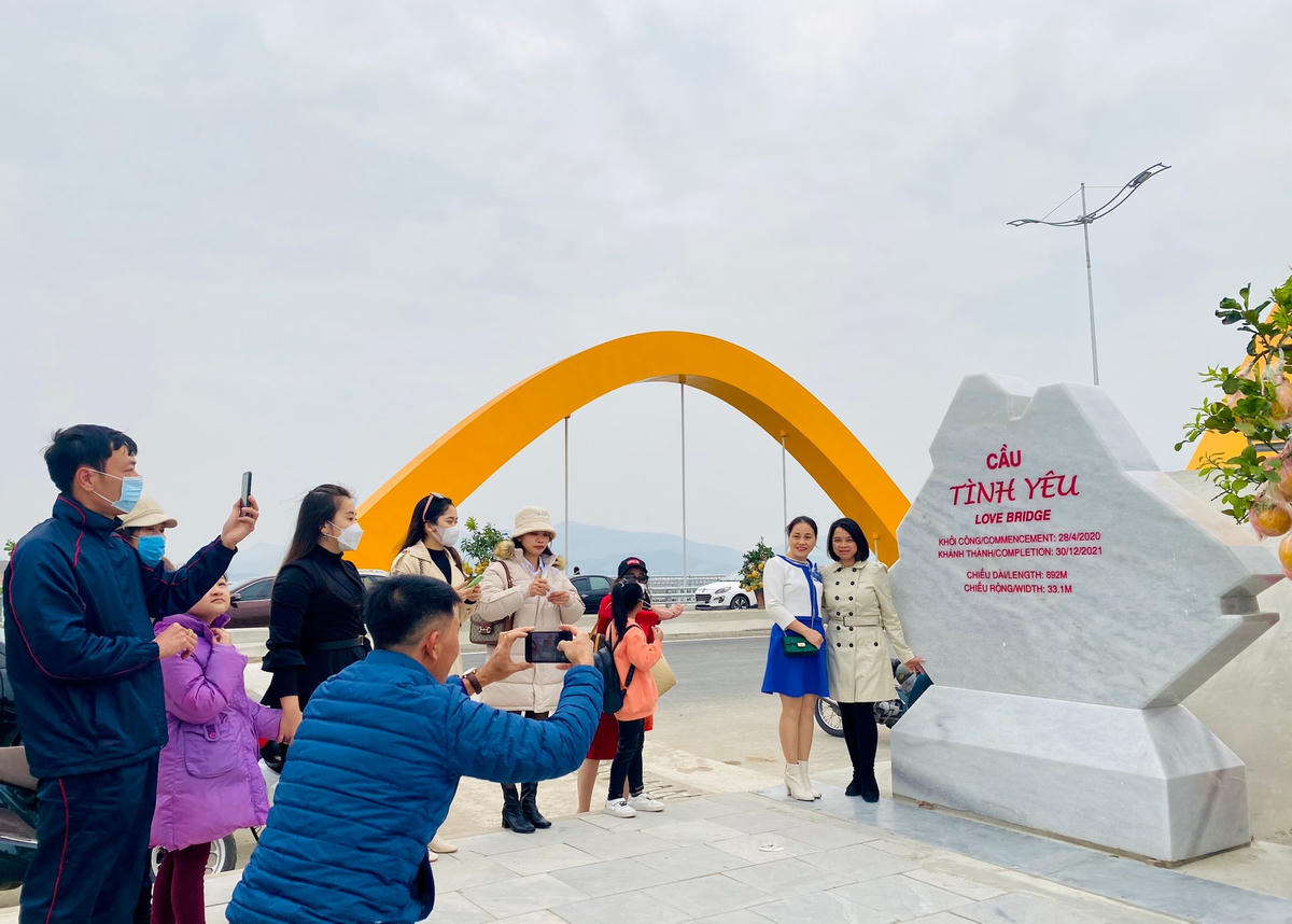 Người dân hồ hởi chờ tới lượt “check in” cùng tấm biển cầu Tình Yêu...