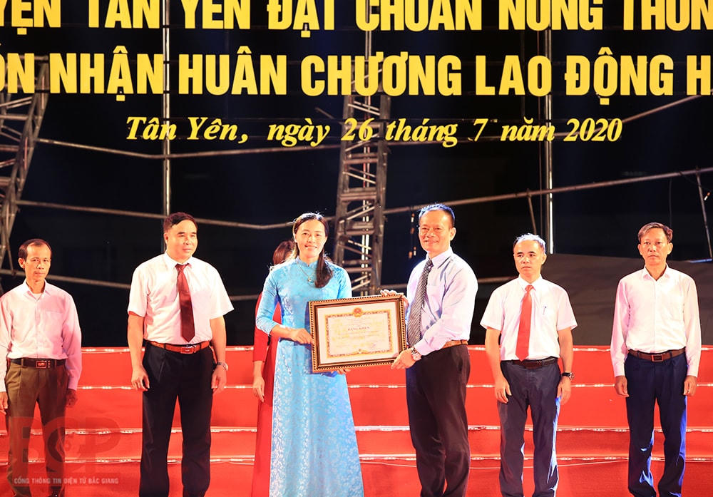 Bà Dương Tuyết Lan - Trưởng ban Dân vận, Chủ tịch Ủy ban MTTQ huyện Tân Yên đón nhận Bằng khen của UBND tỉnh tặng đơn vị có nhiều đóng góp trong xây dựng NTM tại Lễ công bố huyện Tân Yên đạt chuẩn NTM.
