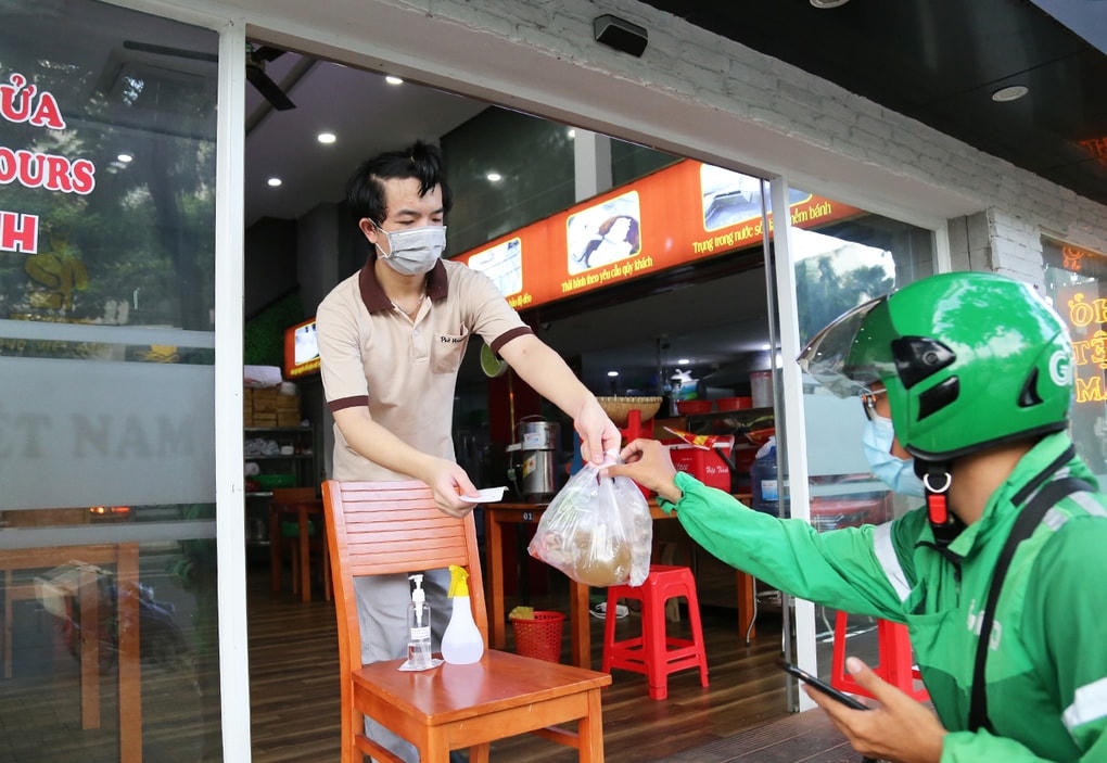 Nhân viên quán phở trên đường Bùi Bằng Đoàn, quận 7 giao hàng cho shipper trong ngày đầu tiên TP HCM cho phép quán ăn bán hàng mang đi, ngày 9/9.