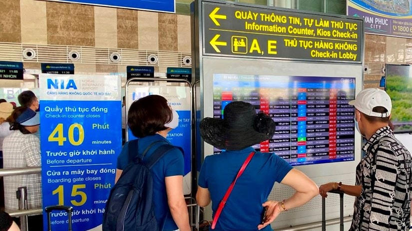 Hành khách theo dõi thông tin chuyến bay tại màn hình FIDS tại sân bay Nội Bài. (Ảnh: Văn phòng Cảng hàng không Nội Bài).