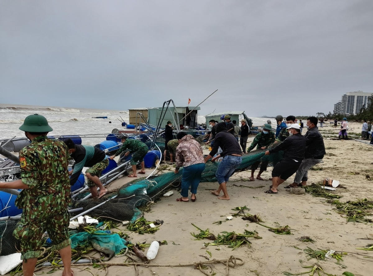 Lực lượng chức năng giúp người dân thu dọn lồng bè bị sóng đánh tơi tả.