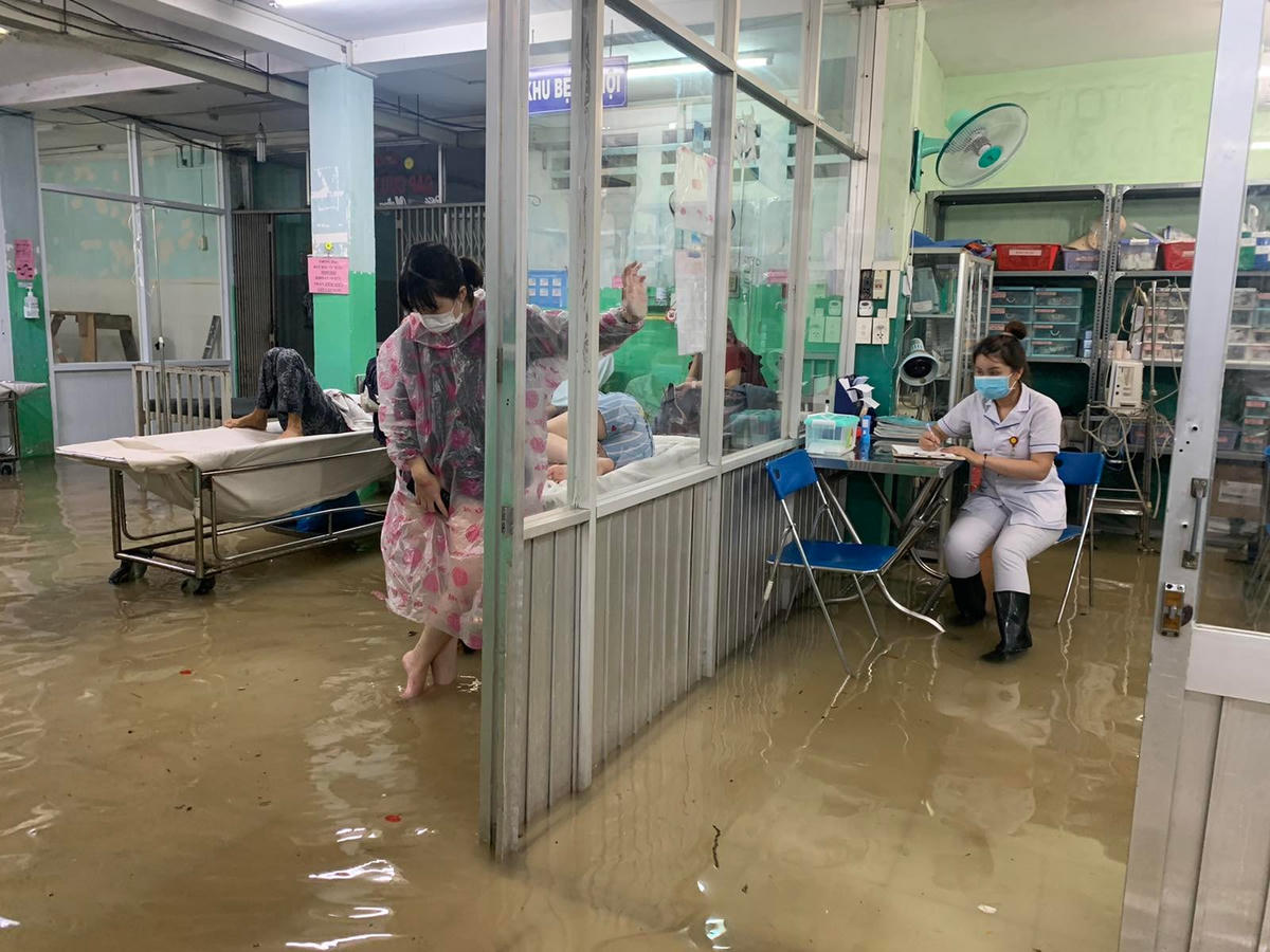 Nước ngập sâu nhưng nhân viên y tế vẫn phải làm thủ tục nhập viện cho bệnh nhân.