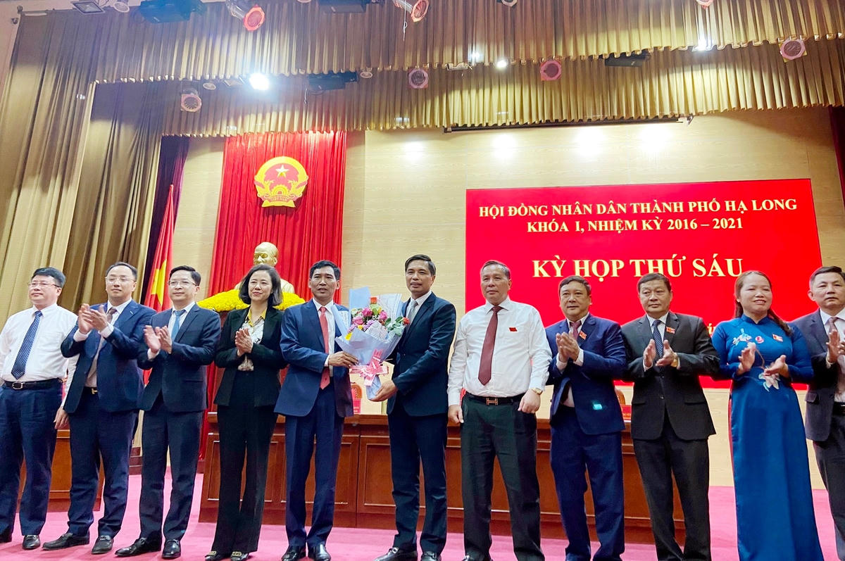 Ông Vũ Văn Diện, Bí thư Thành ủy Hạ Long tặng hoa chúc mừng ông Nguyễn Tiến Dũng, tân Chủ tịch UBND thành phố Hạ Long