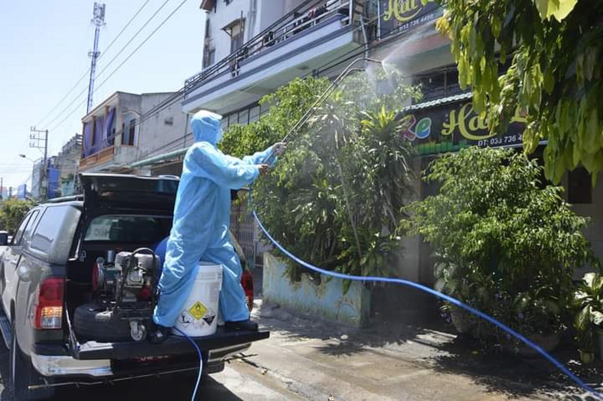 Lực lượng chức năng phun thuốc khử khuẩn dọc tuyến đường ở thị xã Đức Phổ.