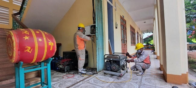 Công nhân Điện lực đang đấu nối máy phát dự phòng điểm thi Trường THPT Tiên Yên (Quảng Ninh).