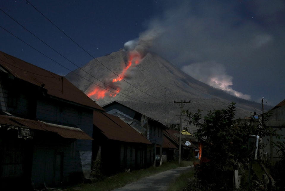 11. Tro phun ra từ núi Sinabung trong một vụ phun trào nhìn từ làng Beras Tepu, tỉnh Bắc Sumatra, Indonesia , ngày 29 tháng 05 năm 2015. Hơn 10.000 người từ 12 làng, những người đang sống xung quanh sườn núi Sinabung, đã phải rời bỏ nhà cửa của họ và di chuyển đến các trại tị nạn, theo truyền thông địa phương. Ảnh Beawiharta / Reuters. 