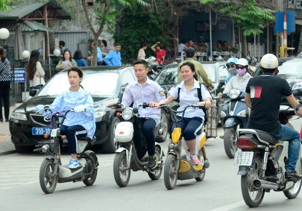 Học sinh đi xe máy điện đến trường.