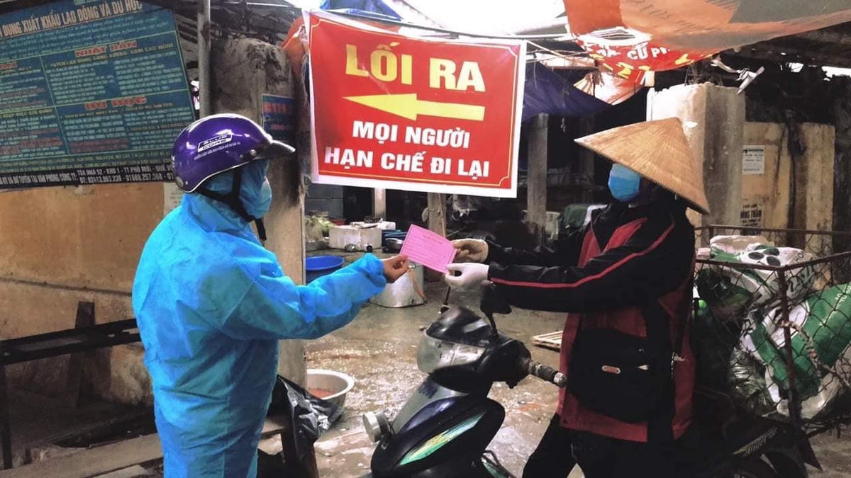 Bà con tiểu thương và người dân được phát phiếu đi chợ.