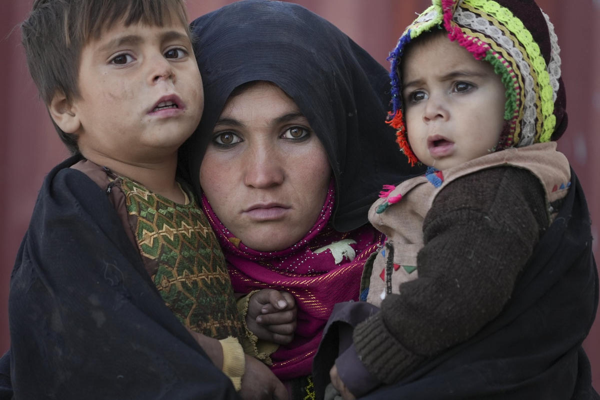 Một phụ nữ Afghanistan và các con của cô ấy đang chờ được tư vấn bên ngoài một phòng khám tạm tại một khu định cư ngổn ngang gồm những túp lều bằng gạch bùn, nơi ở của những người dân phải di dời vì chiến tranh và hạn hán gần thành phố Herat. Ảnh: Mstyslav Chernov / AP.