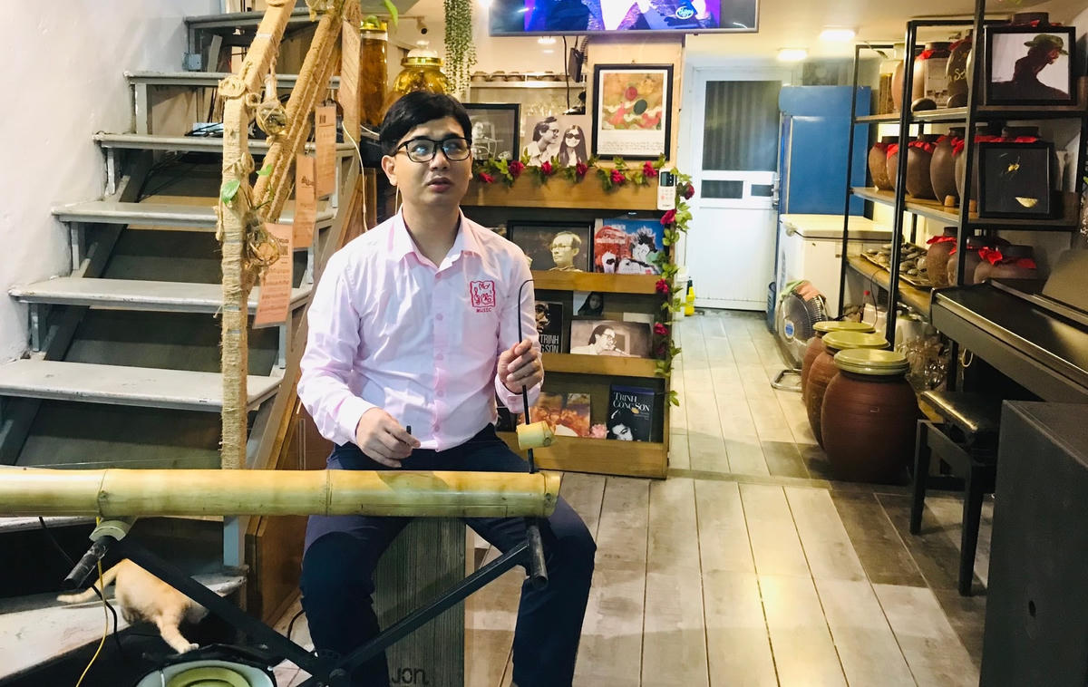 Anh Quốc Hoàn, người chơi guitar và đàn bầu trong Ban nhạc Mơ Phố.