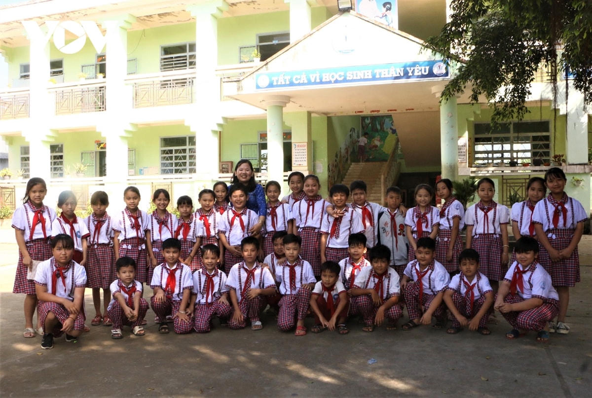 Cô Phạm Minh Thùy cùng các em học sinh tại trường Tiểu học thị trấn Cù Lao Dung.  