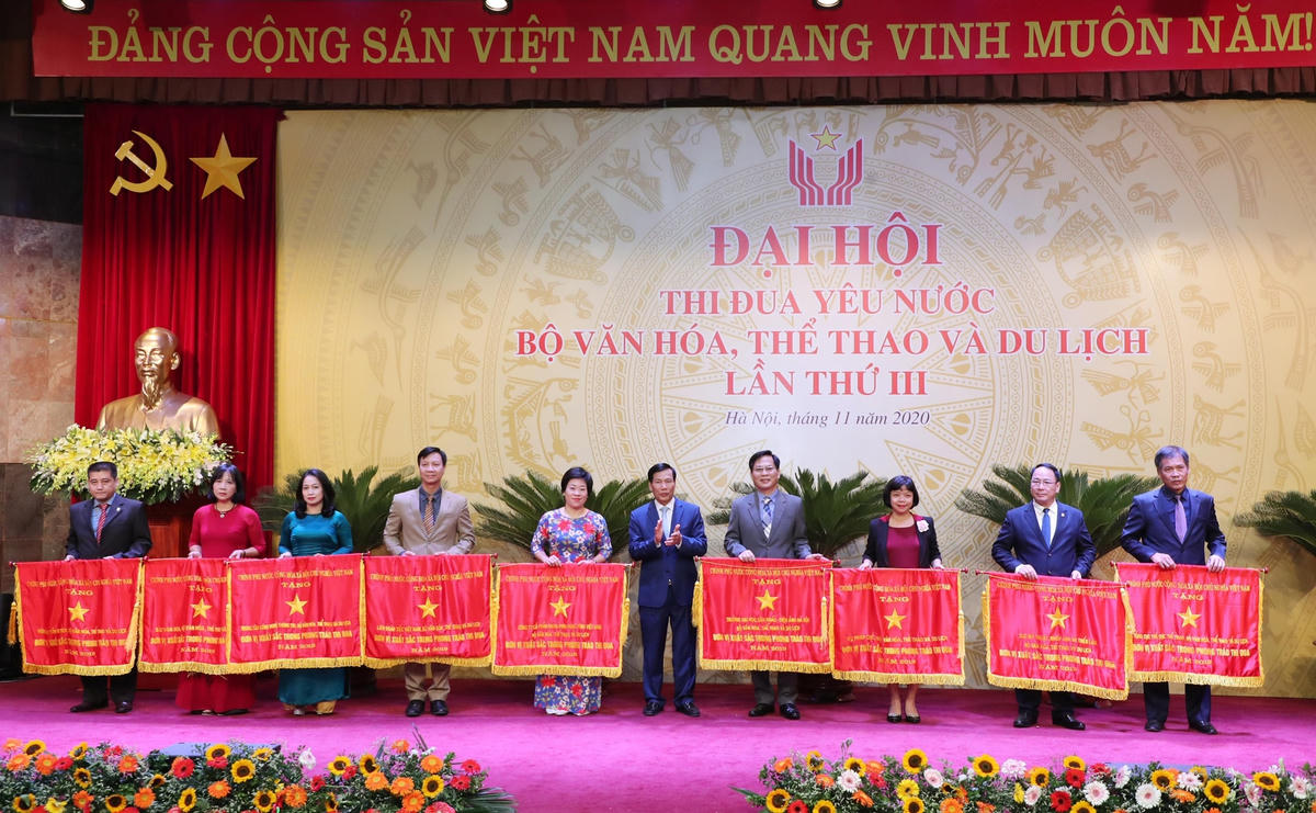 Bộ trưởng Bộ VHTTDL Nguyễn Ngọc Thiện trao Cờ Thi đua Chính phủ cho 10 đơn vị có thành tích xuất sắc trong năm 2019. Ảnh: Trần Huấn.