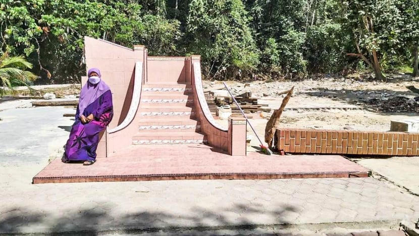 Rohana Mahfuz đã mất tất cả, chỉ còn lại phần cầu thang và cây cột của ngôi nhà sau trận lụt xối xả vào tháng 12/2021. Ảnh: CNA.