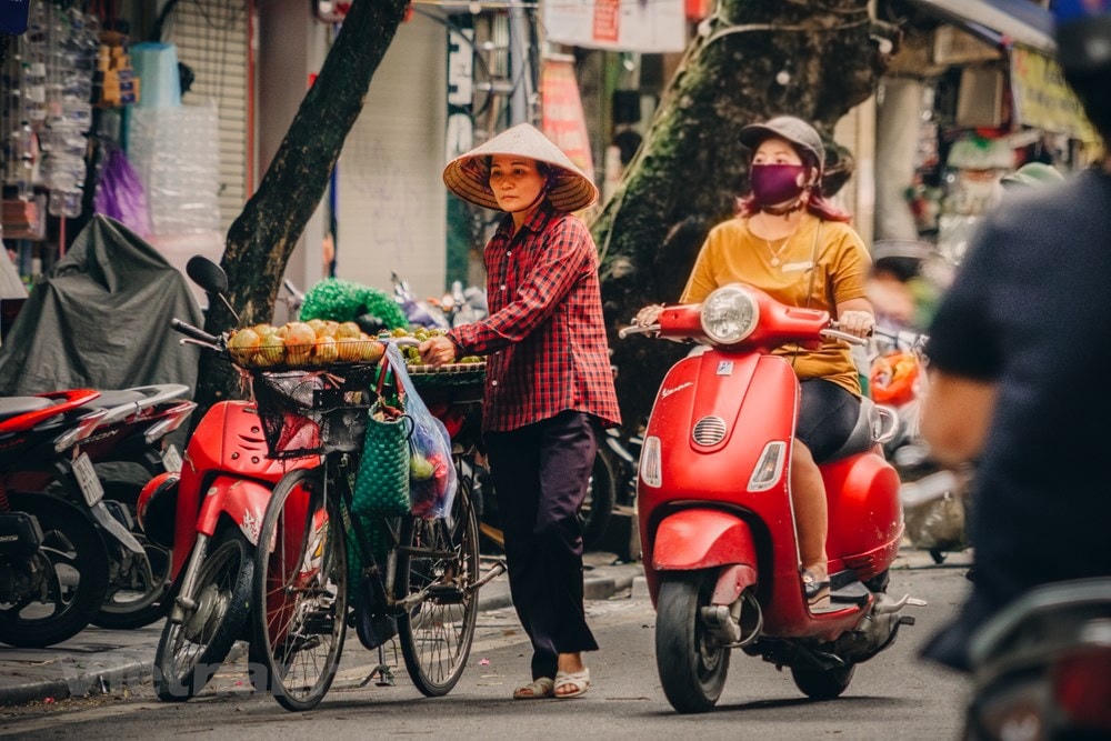 Những gánh hàng hoa mộc mạc vẫn cần mẫn làm đẹp cho đời, cho người, hoa càng đẹp càng đáng quý hơn khi đằng sau gánh hoa còn cả một cuộc sống mưu sinh vất vả. (Ảnh: Minh Hiếu/Vietnam+).