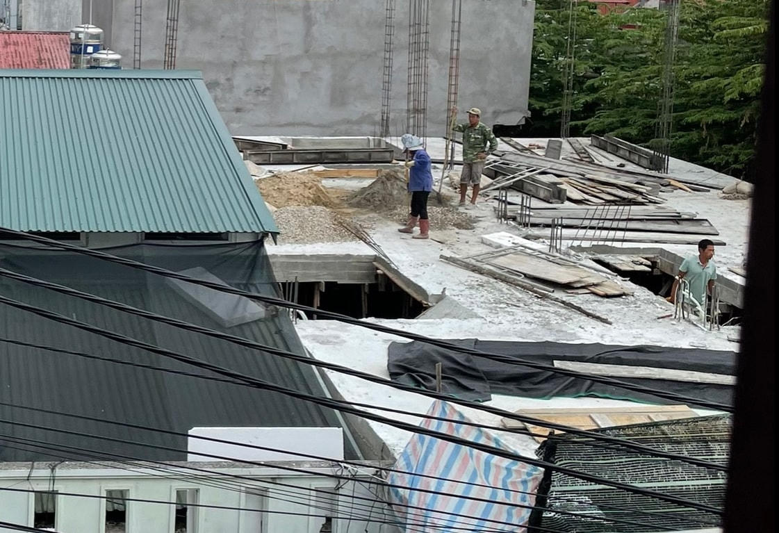 Thợ xây dựng đang ghép cốp pha đổ bê tông trụ cọc để xây tầng hai của dãy nhà.