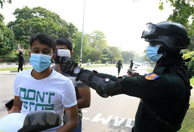 Kiểm tra thân nhiệt cho người dân nhằm kiểm soát sự lây lan của dịch COVID-19 tại Colombo, Sri Lanka. Ảnh: THX/TTXVN.  
