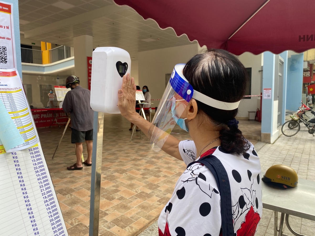 Người dân đo thân nhiệt trước khi vào mua hàng.