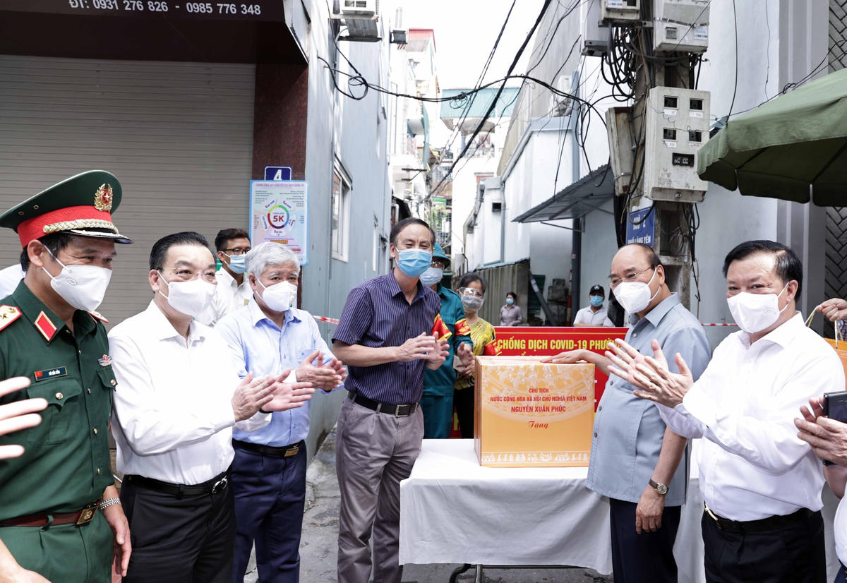 Chủ tịch nước Nguyễn Xuân Phúc, Chủ tịch UBTƯ MTTQ Việt Nam Đỗ Văn Chiến thăm và động viên cán bộ, nhân dân tại điểm tiêm vaccine phòng, chống Covid-19 tại phường Bạch Đằng, quận Hai Bà Trưng, Hà Nội.