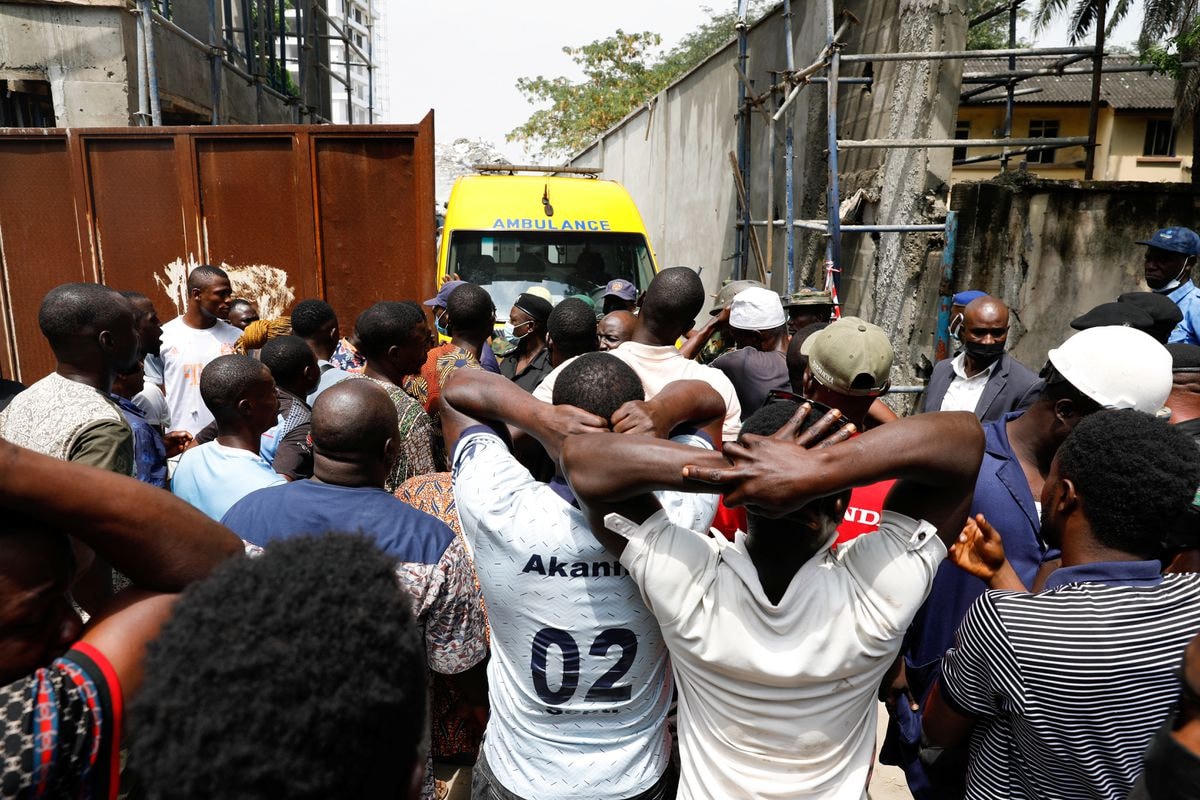 Người dân xếp hàng dài phía ngoài hiện trường sự cố ở thành phố Lagos, Nigeria. Ảnh: Reuters.