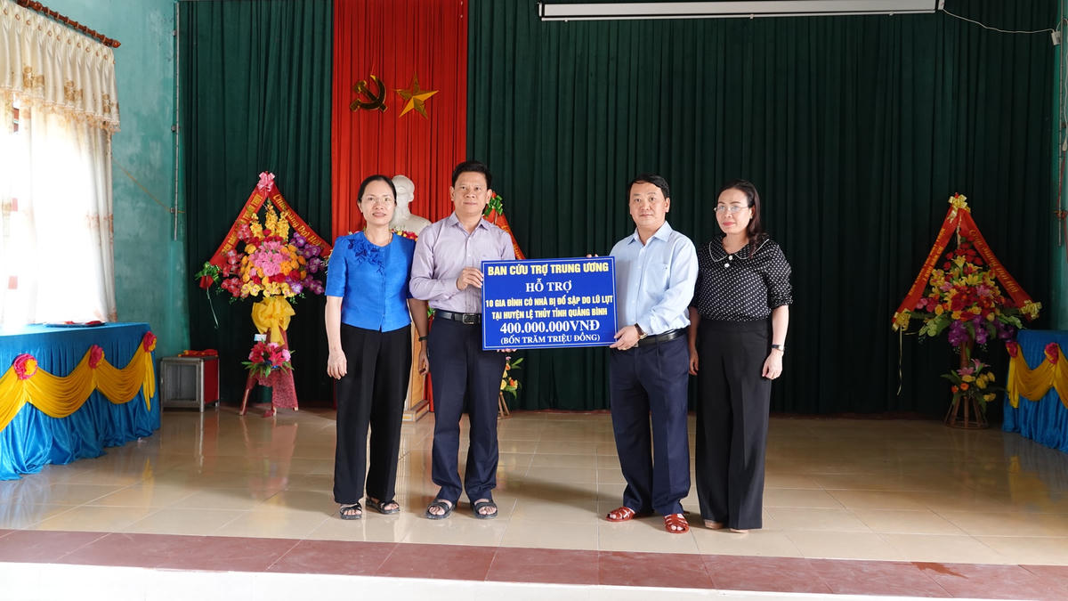 Phó Chủ tịch - Tổng Thư ký Hầu A Lềnh trao biểu trưng 10 nhà Đại đoàn kết, trị giá 400 triệu đồng cho UBND huyện Lệ Thuỷ.