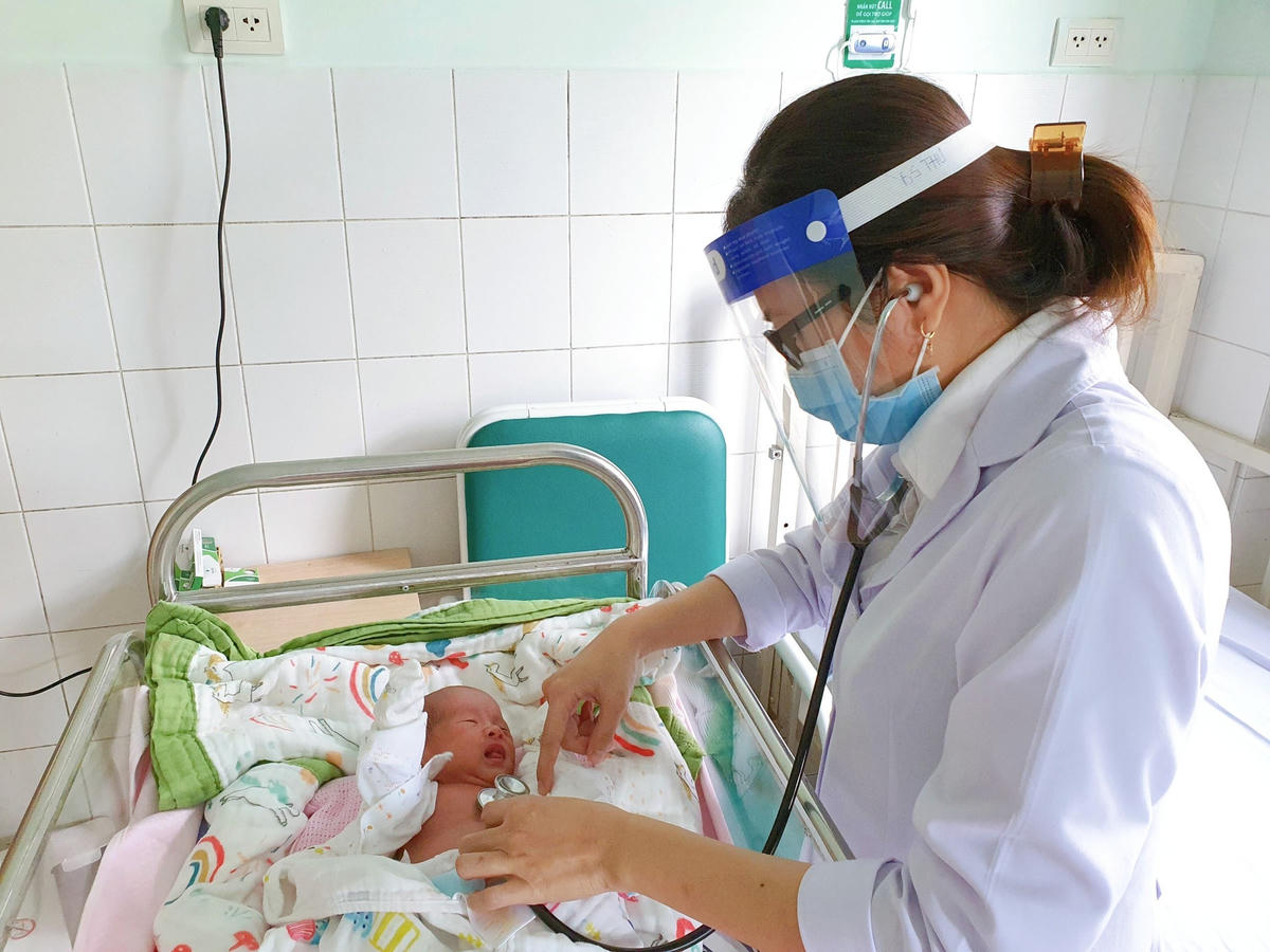 Bác sĩ thăm khám, kiểm tra sức khoẻ bé trước khi xuất viện.