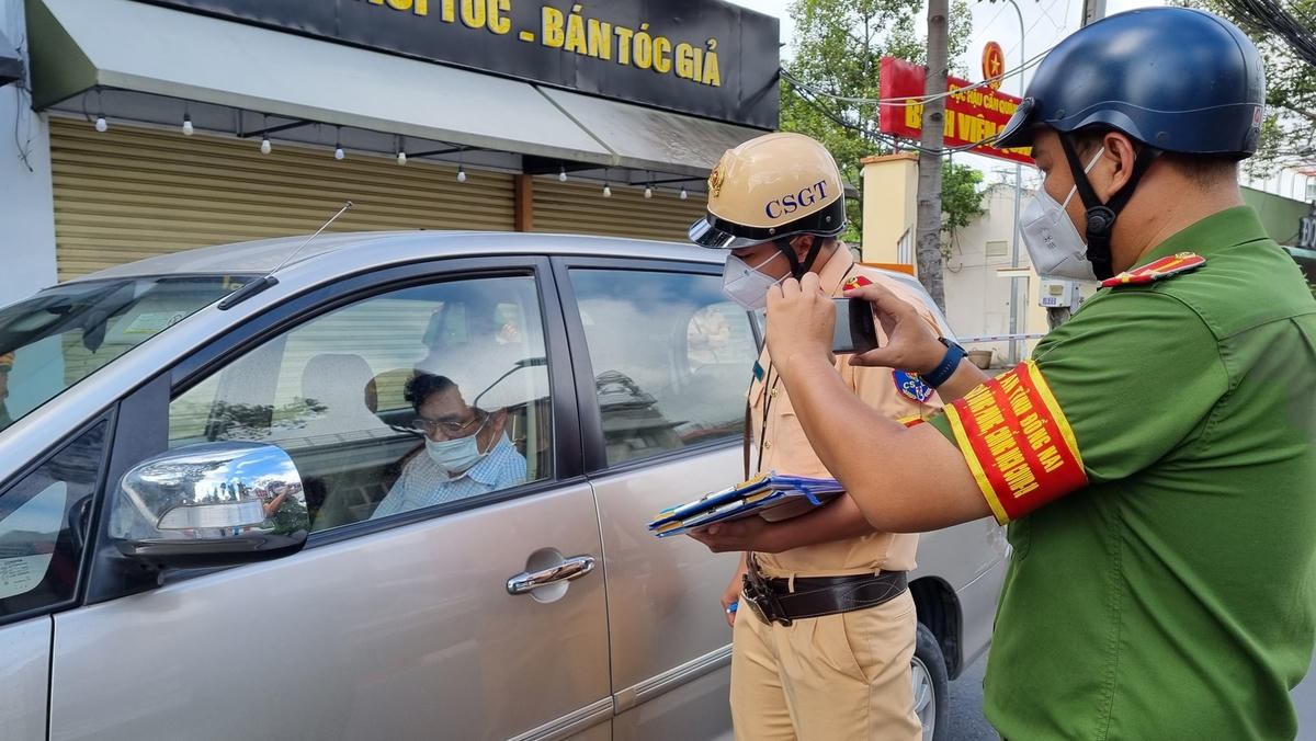 Tuy lực lượng chức năng nhiều lần thuyết phục nhưng ông Lê Văn Chính vẫn cố thủ trong xe, không chấp hành việc kiểm tra. Ảnh: Lê Bình. 