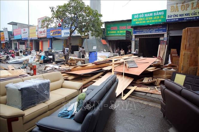 Nhiều người dân đã cùng lực lượng chức năng di chuyển đồ của những nhà bên cạnh đám cháy ra ngoài để tránh cháy lan. Ảnh: TTXVN phát.