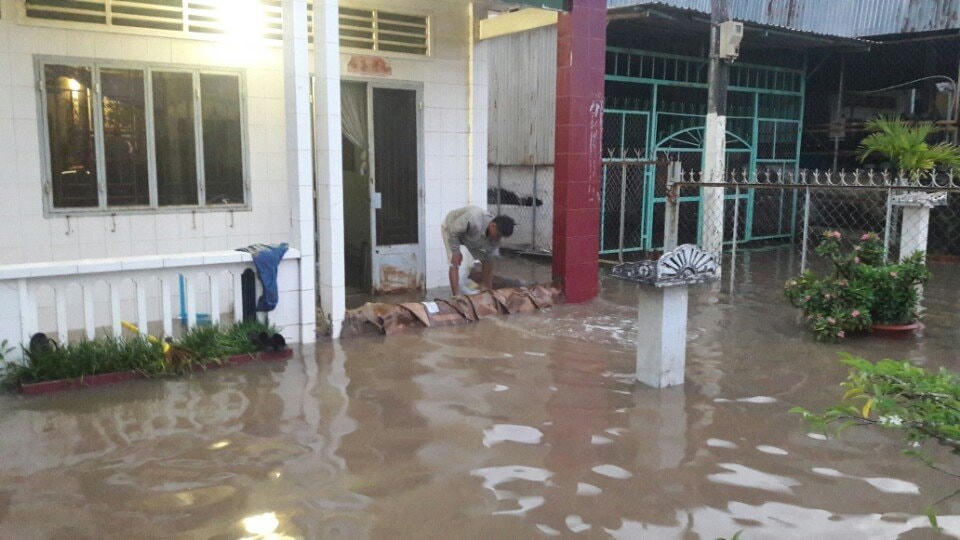 Người dân phải đắp bờ bằng những bao cát để ngăn triều cường tràn vào nhà.