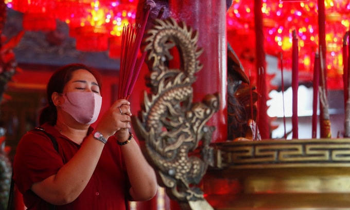 Một người phụ nữ thắp hương tại ngôi đền ở thủ đô Jakarta của Indonesia tối 11/2. Ảnh: Reuters.