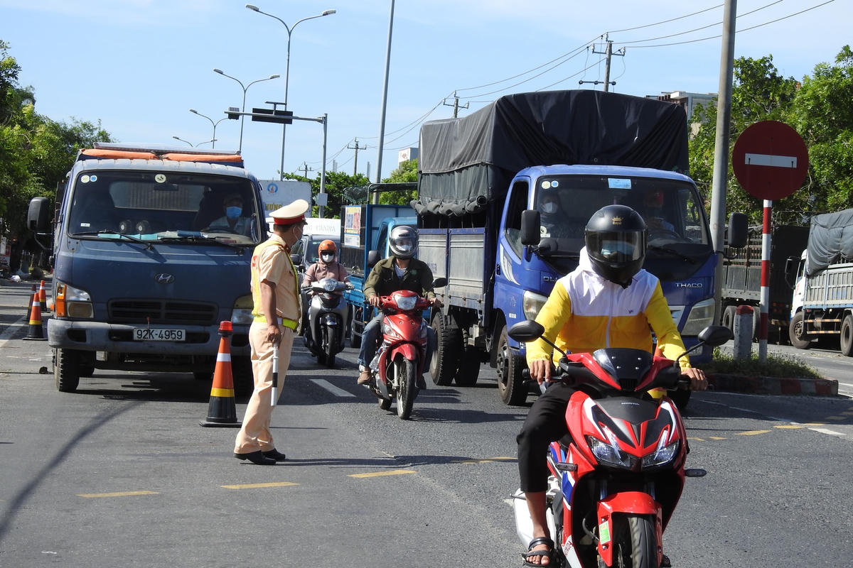 Ước tính mỗi giờ có hàng trăm lượt người điều khiển xe máy thực hiện khai báo y tế tại chốt kiểm soát phòng, chống dịch Covid-19 QL 1A cửa ngõ phía Nam Đà Nẵng. Ảnh Thanh Tùng.