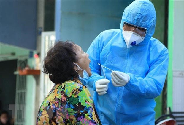 Nhân viên y tế lấy mẫu xét nghiệm người dân trong khu vực Lô E, Lò Gốm (phường 7, quận 6, TP HCM). Ảnh: TTXVN.