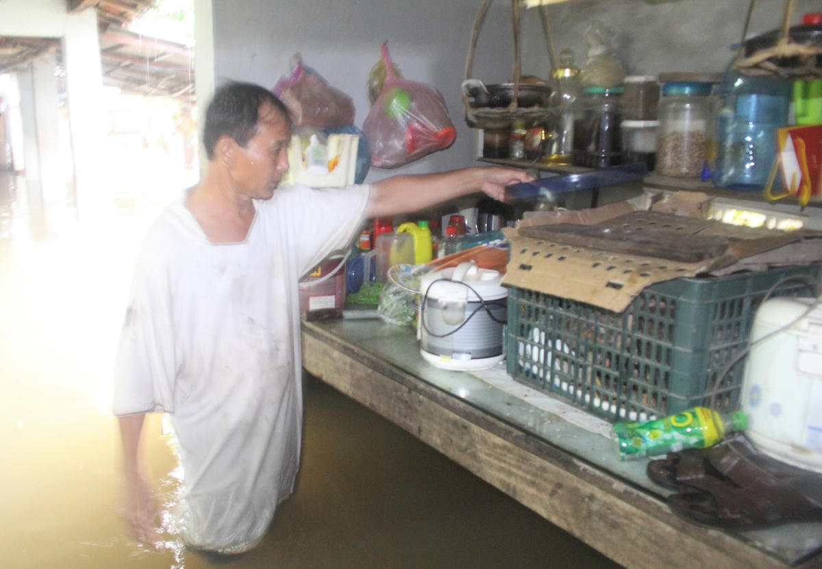Ông Nguyễn Thanh Tùng chỉ nhà ngập nước phải kê đồ đạc lên cao.