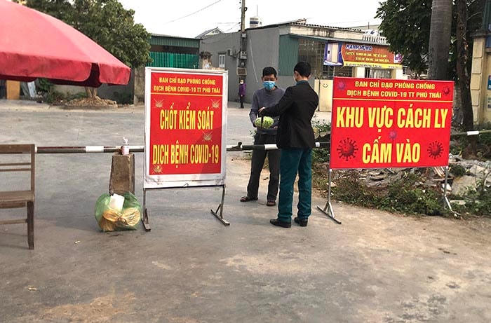  Lực lượng chức năng thị trấn Phú Thái hỗ trợ người dân trong khu cách ly An Thái mua lương thực, thực phẩm. Ảnh: Báo Hải Dương.