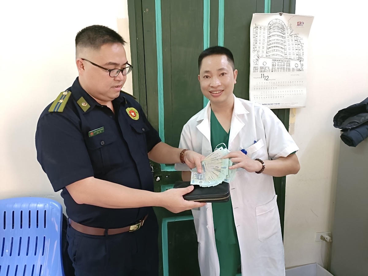 Anh Vương Duy Thành thay mặt người nhà bị rơi túi là anh Nguyễn Thành Công (đi khám tại Bệnh viện Hữu nghị Việt Đức) nhận lại số tiền đánh rơi từ nhân viên bảo vệ bệnh viện.