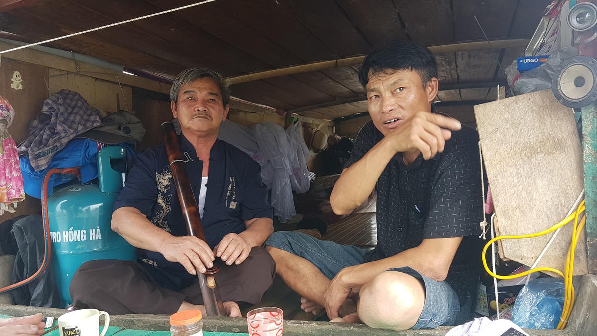 Ông Nguyễn Văn Vĩnh (trái) trên chiếc thuyền của anh Trang tại lòng hồ Suối Hai (Ba Vì - Hà Nội).